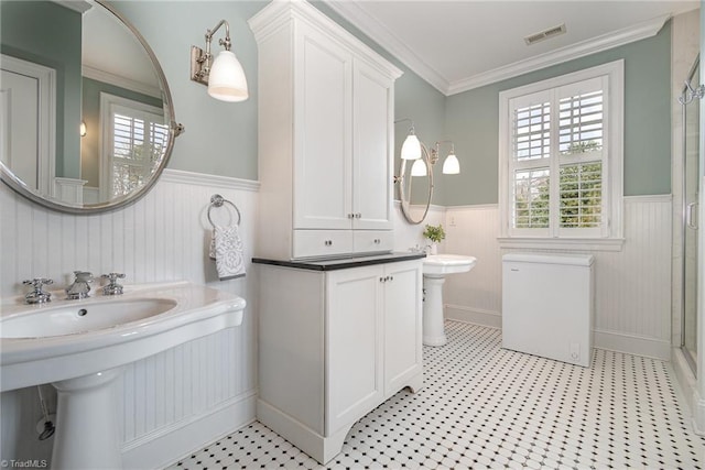 bathroom with visible vents, a stall shower, wainscoting, crown molding, and tile patterned floors