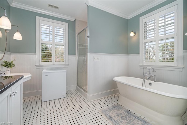 bathroom featuring a shower stall, crown molding, a wainscoted wall, a freestanding tub, and vanity