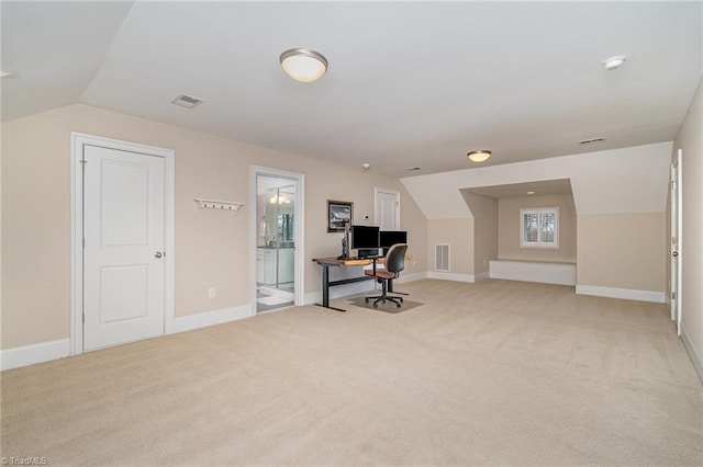 home office with lofted ceiling, baseboards, visible vents, and light carpet