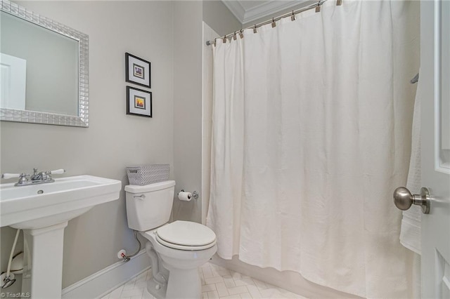 bathroom with toilet, a shower with shower curtain, baseboards, and a sink