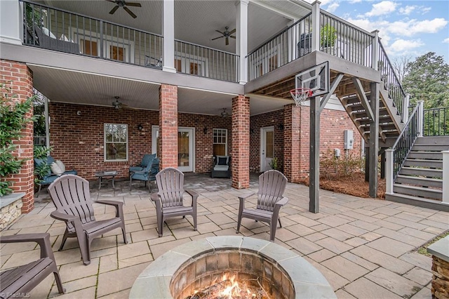 view of patio featuring stairway, a fire pit, and ceiling fan