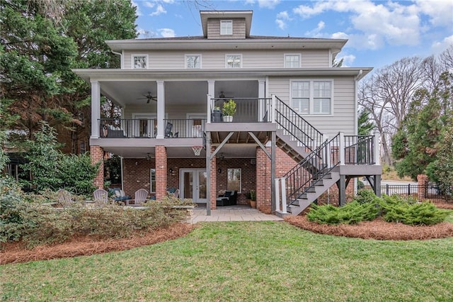 back of house featuring a ceiling fan, a yard, brick siding, stairs, and a patio area