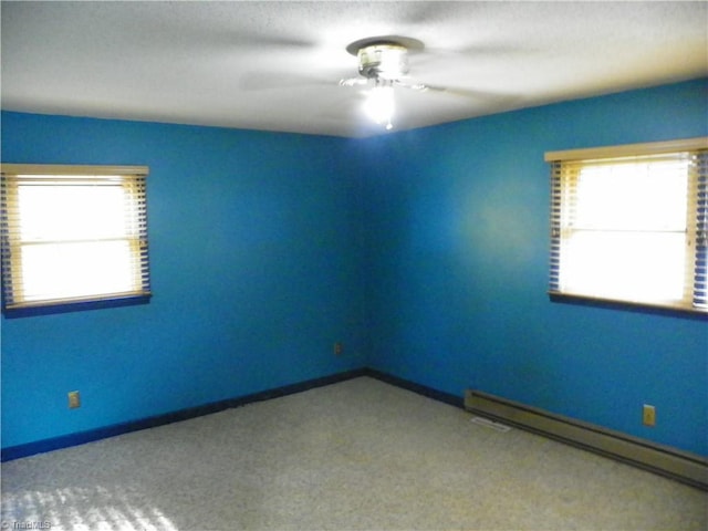 carpeted empty room featuring baseboard heating and ceiling fan