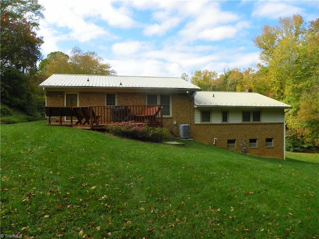 back of house featuring a wooden deck, a lawn, and central AC unit