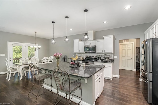 817 Jefferson Rd, Greensboro, NC 27410 - kitchen with appliances with stainless steel finishes, a breakfast bar area, white cabinets, dark wood-type flooring, and recessed lighting