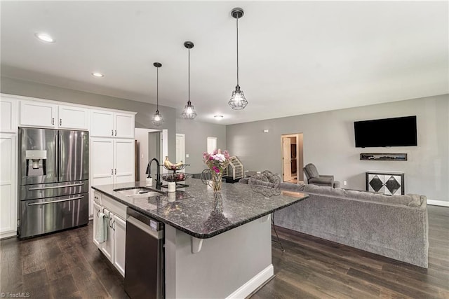 817 Jefferson Rd, Greensboro, NC 27410 - kitchen with stainless steel appliances, dark wood finished floors, a sink, white cabinetry, and dark stone counters