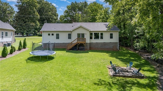 817 Jefferson Rd, Greensboro, NC 27410 - back of house featuring a fire pit, a trampoline, crawl space, and a yard