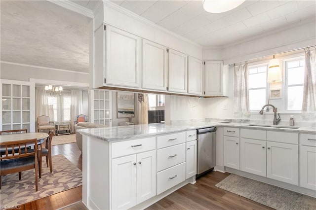 kitchen featuring ornamental molding, stainless steel dishwasher, a sink, and white cabinetry