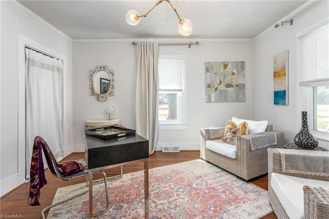 sitting room featuring ornamental molding, visible vents, and wood finished floors