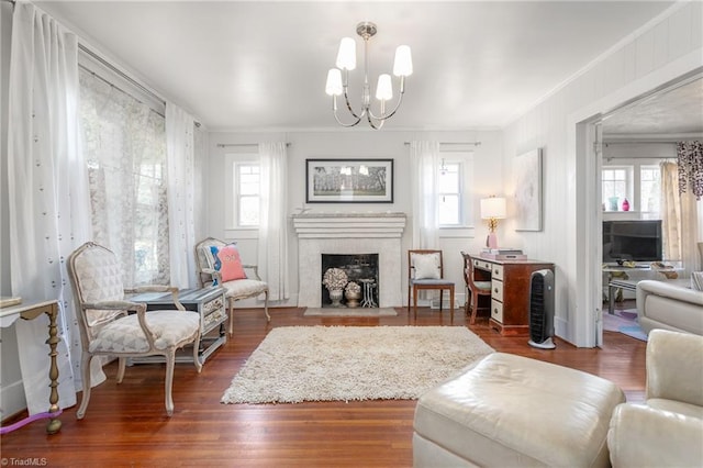 interior space featuring dark wood-style floors, crown molding, a notable chandelier, and a fireplace with flush hearth