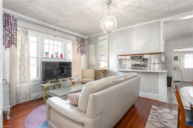 living room with a chandelier, ornamental molding, dark wood-style flooring, and baseboards