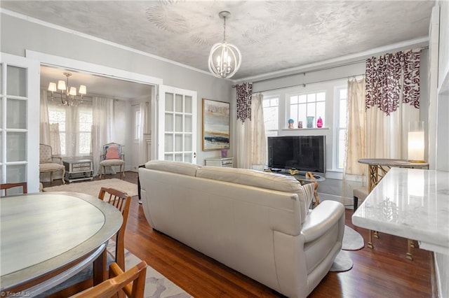 living room with a healthy amount of sunlight, an inviting chandelier, and dark wood-style floors