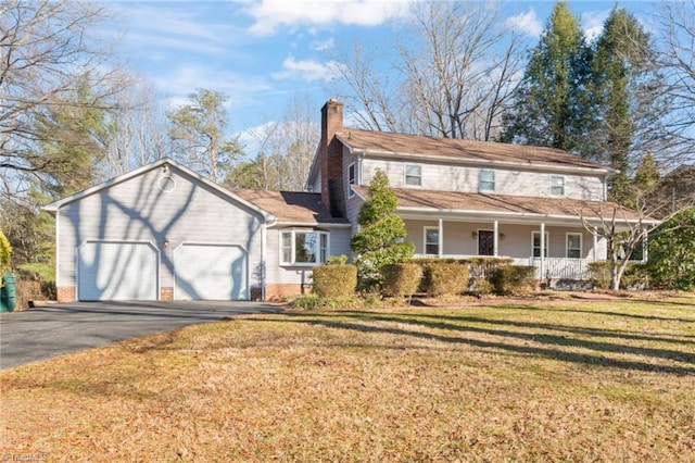 view of property featuring a front lawn, covered porch, and a garage