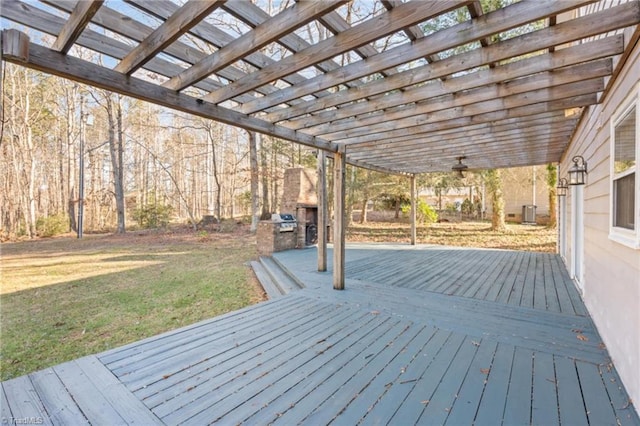 deck with exterior fireplace and a lawn