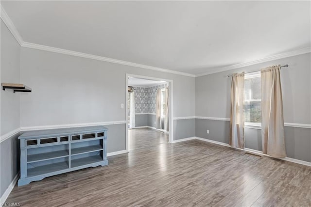 empty room with hardwood / wood-style flooring and crown molding