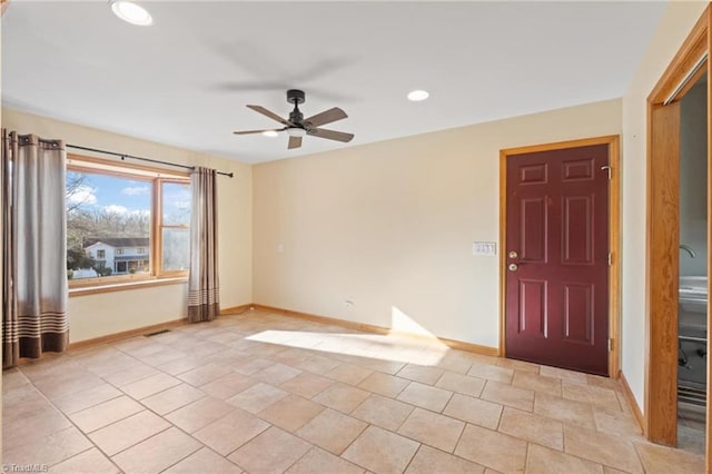 tiled empty room featuring ceiling fan