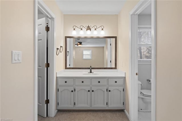 bathroom with ceiling fan, vanity, and toilet