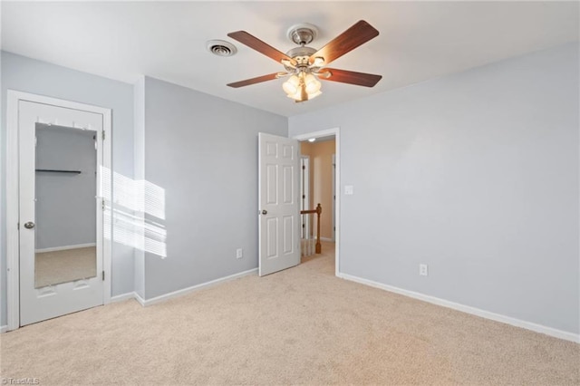 unfurnished bedroom with light colored carpet and ceiling fan