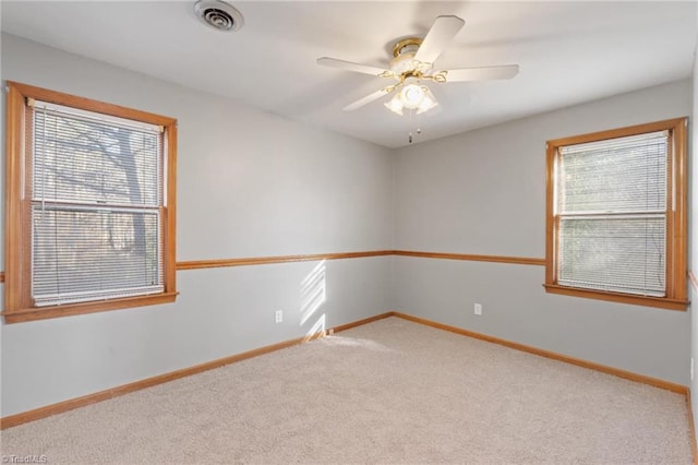 carpeted spare room featuring ceiling fan