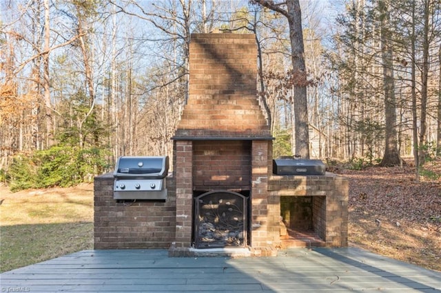 wooden deck featuring area for grilling and an outdoor fireplace