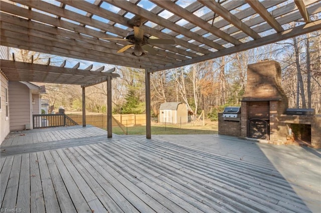 deck featuring area for grilling, a pergola, an outdoor fireplace, and a yard