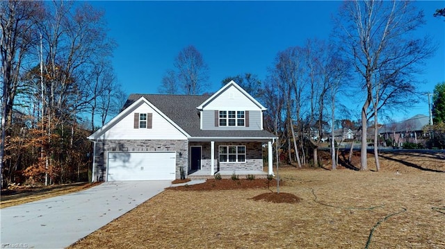 traditional-style home with a porch, stone siding, and driveway