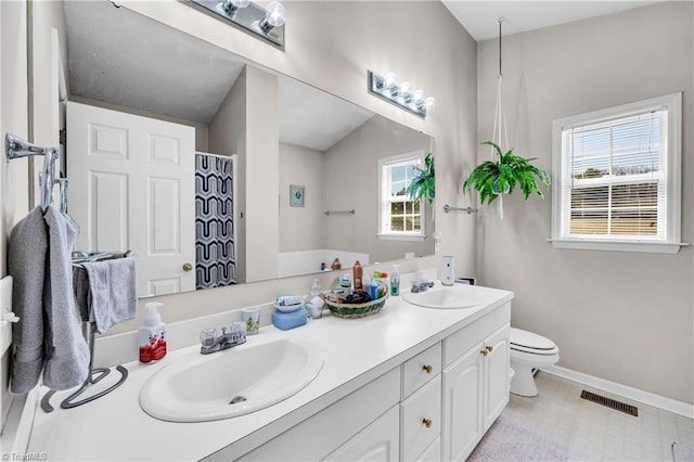 bathroom featuring a sink, visible vents, baseboards, and toilet