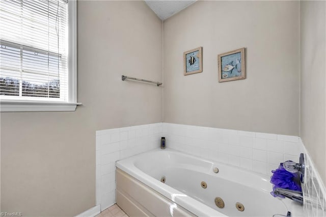 full bathroom featuring a tub with jets and baseboards