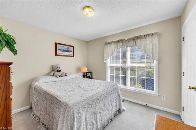 bedroom featuring baseboards, carpet floors, and a textured ceiling