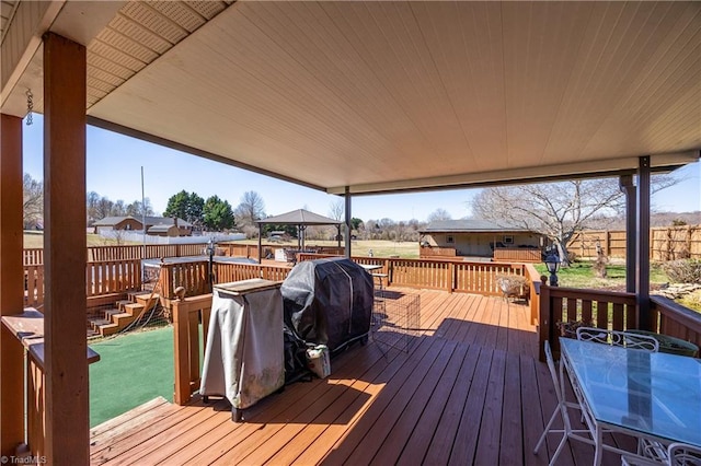 wooden deck featuring a gazebo, fence, a lawn, and grilling area