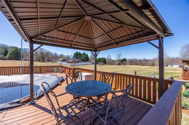 wooden terrace featuring a gazebo, a yard, and outdoor dining space