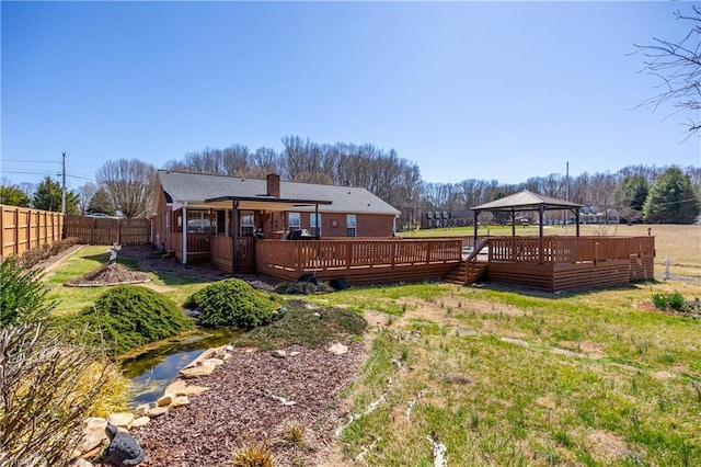 view of yard featuring a gazebo, a wooden deck, and a fenced backyard