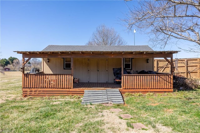 rear view of house with a wooden deck and a lawn