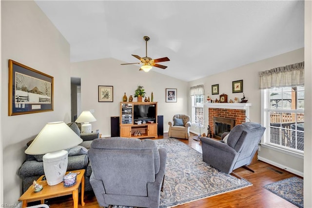 living room with a fireplace, lofted ceiling, plenty of natural light, and wood finished floors