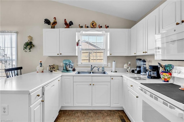 kitchen featuring white appliances, a peninsula, a wealth of natural light, and a sink