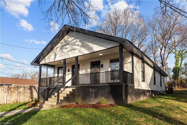 bungalow featuring central AC, covered porch, and a front yard