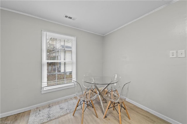 dining area featuring hardwood / wood-style flooring and ornamental molding