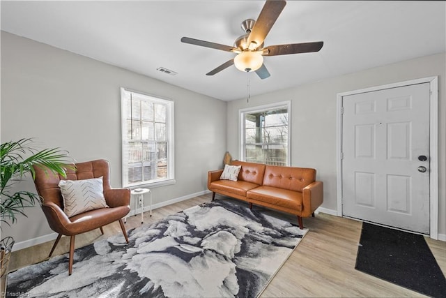 sitting room with ceiling fan and light wood-type flooring