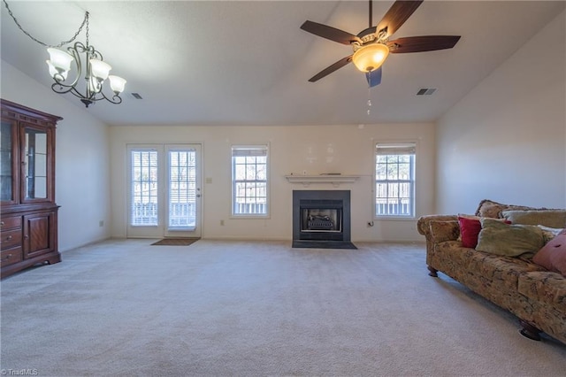 carpeted living room with ceiling fan with notable chandelier