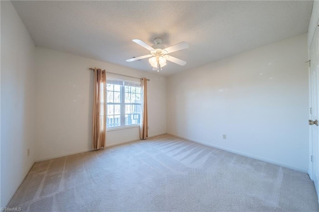 empty room with ceiling fan and light colored carpet