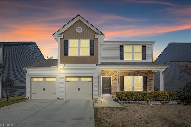 view of front of property with brick siding, an attached garage, and driveway