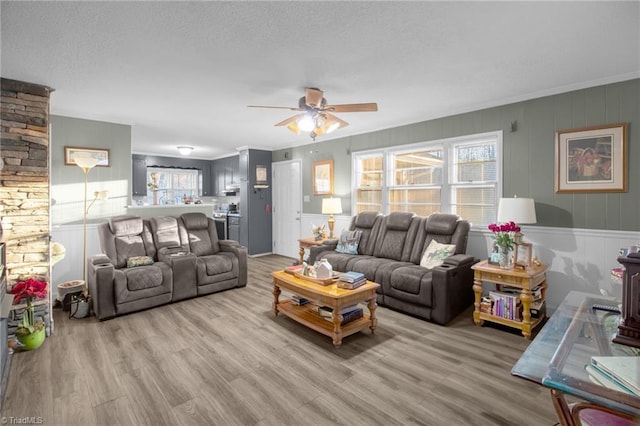 living room featuring crown molding, ceiling fan, and light hardwood / wood-style floors