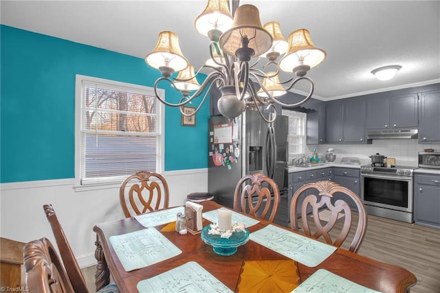 dining room featuring hardwood / wood-style flooring, sink, and a notable chandelier