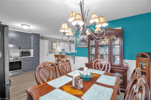 dining space featuring light wood-type flooring and an inviting chandelier