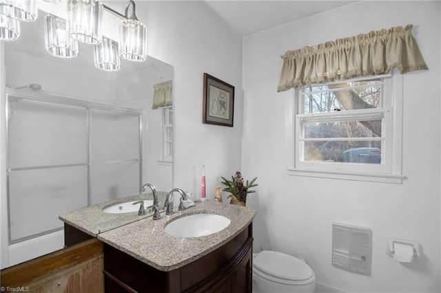 bathroom with an inviting chandelier, vanity, toilet, and an enclosed shower