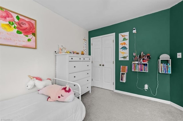 carpeted bedroom with a closet and baseboards