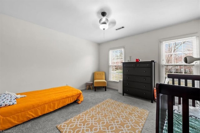 carpeted bedroom with baseboards, visible vents, and ceiling fan