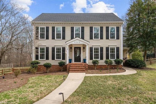 view of front facade with a front lawn and fence