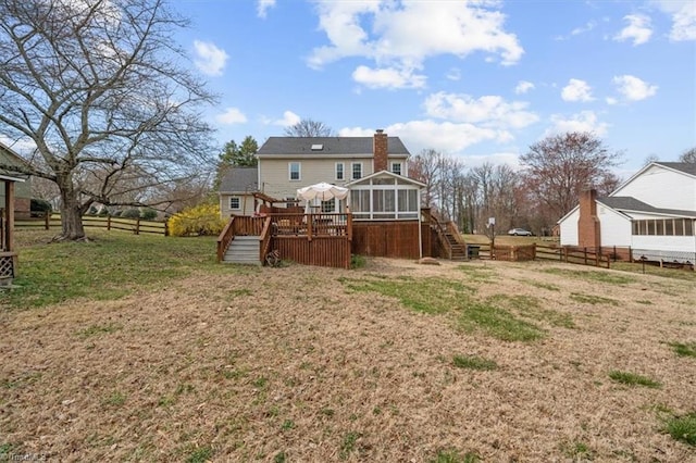 back of property featuring a wooden deck, fence, stairs, and a sunroom