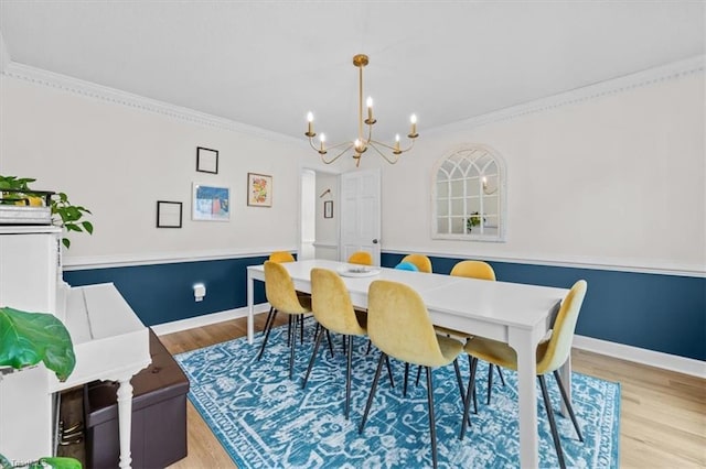 dining room with light wood-style flooring, baseboards, a chandelier, and ornamental molding